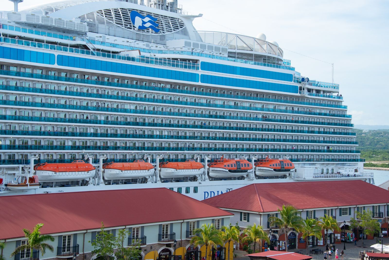 Princess Cruises ship docked beside a Caribbean pier, one of the cruise lines owned by Carnival Corporation
