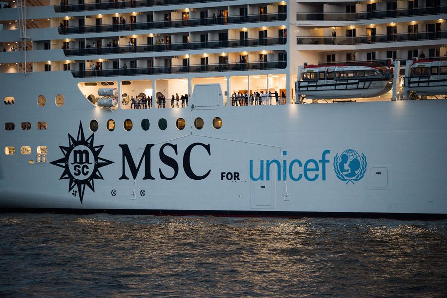 Side of an MSC Cruises ship lit up in the evening